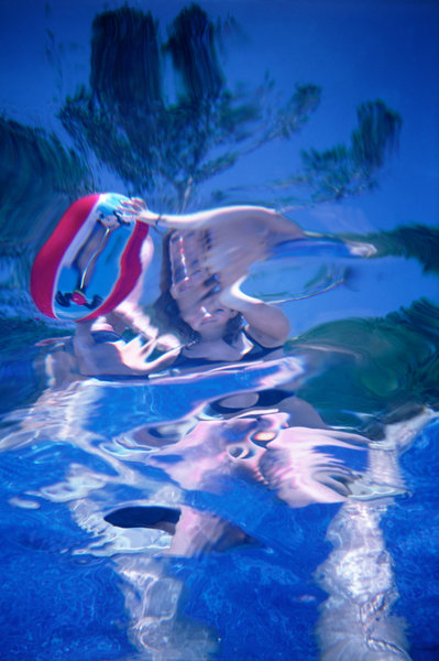 Flicka med badboll (fotograferat under vattnet).