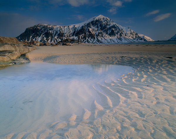 Fj�lltoppar vid sandstrand.